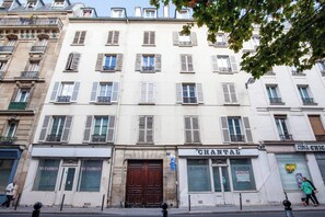 A multi-story building with storefronts on the ground floor, including a visible shop named 'CHANTAL'. - Beautiful Modern Apartment for 4 near Bastille (Paris)