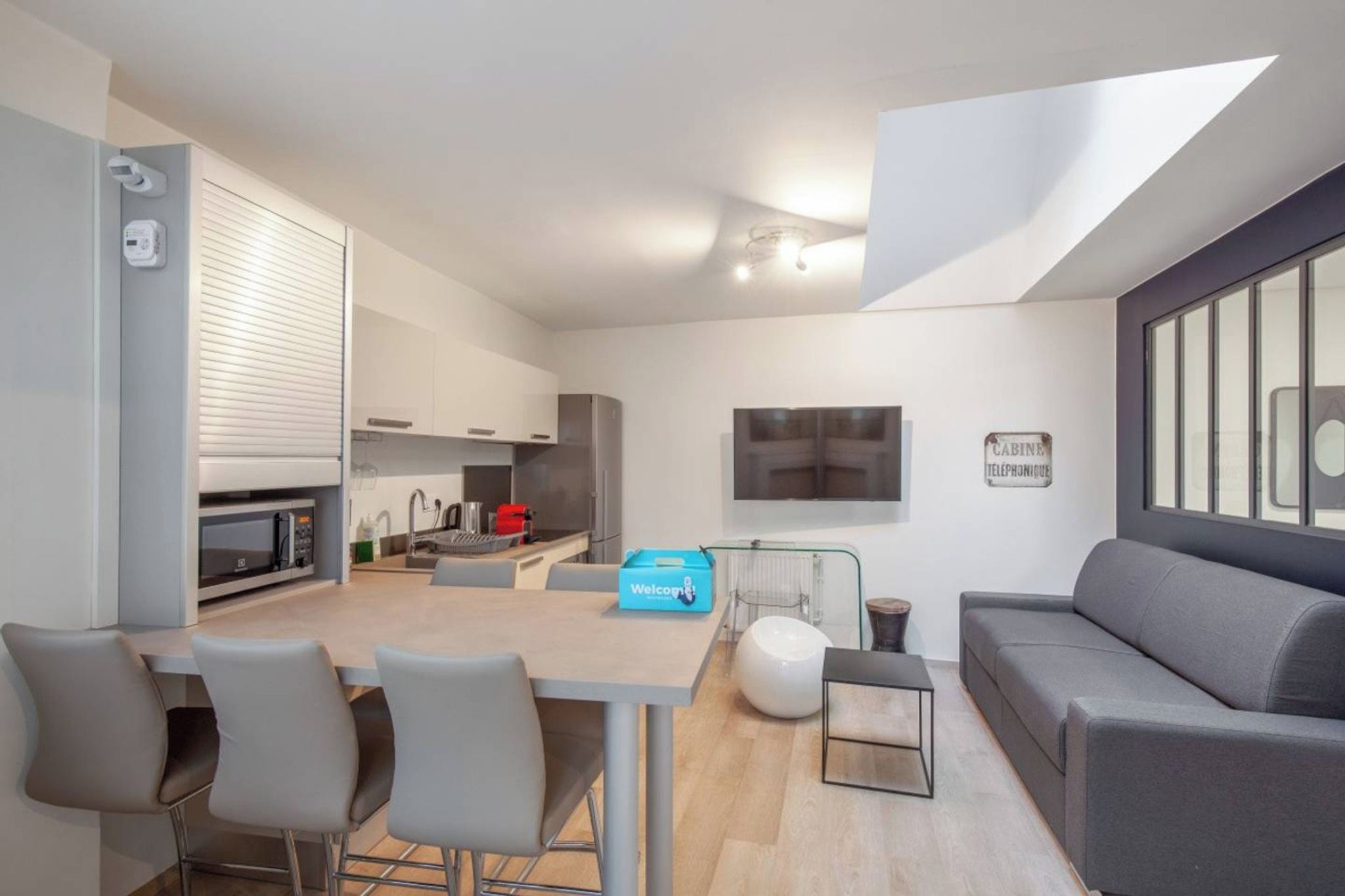 A modern living space with a dining area, kitchen, and seating area.