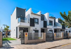 Ein modernes, mehrgeschossiges Wohngebäude mit klarem, minimalistischem Design, das große Fenster und ein Flachdach aufweist.