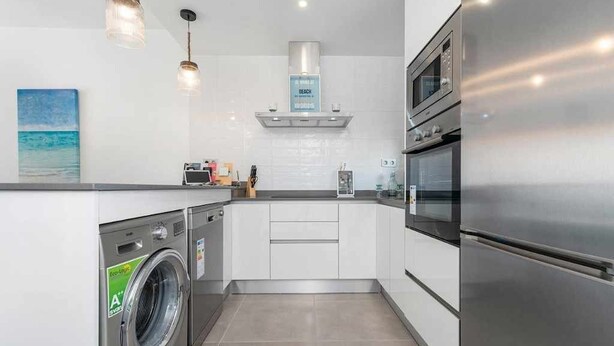 A modern kitchen with a built-in washer, stainless steel appliances, and pendant lighting. - Groundfloor Lamarii Pilar de la Horadada (Pilar de la Horadada)
