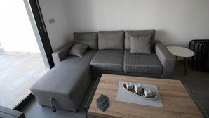 A modern living room with a sectional sofa, a small round table, and a coffee table with a tray of items. - Groundfloor Lamarii Pilar de la Horadada (Pilar de la Horadada)