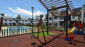 A pool area with a slide and a pergola structure. - Groundfloor Lamarii Pilar de la Horadada (Pilar de la Horadada)