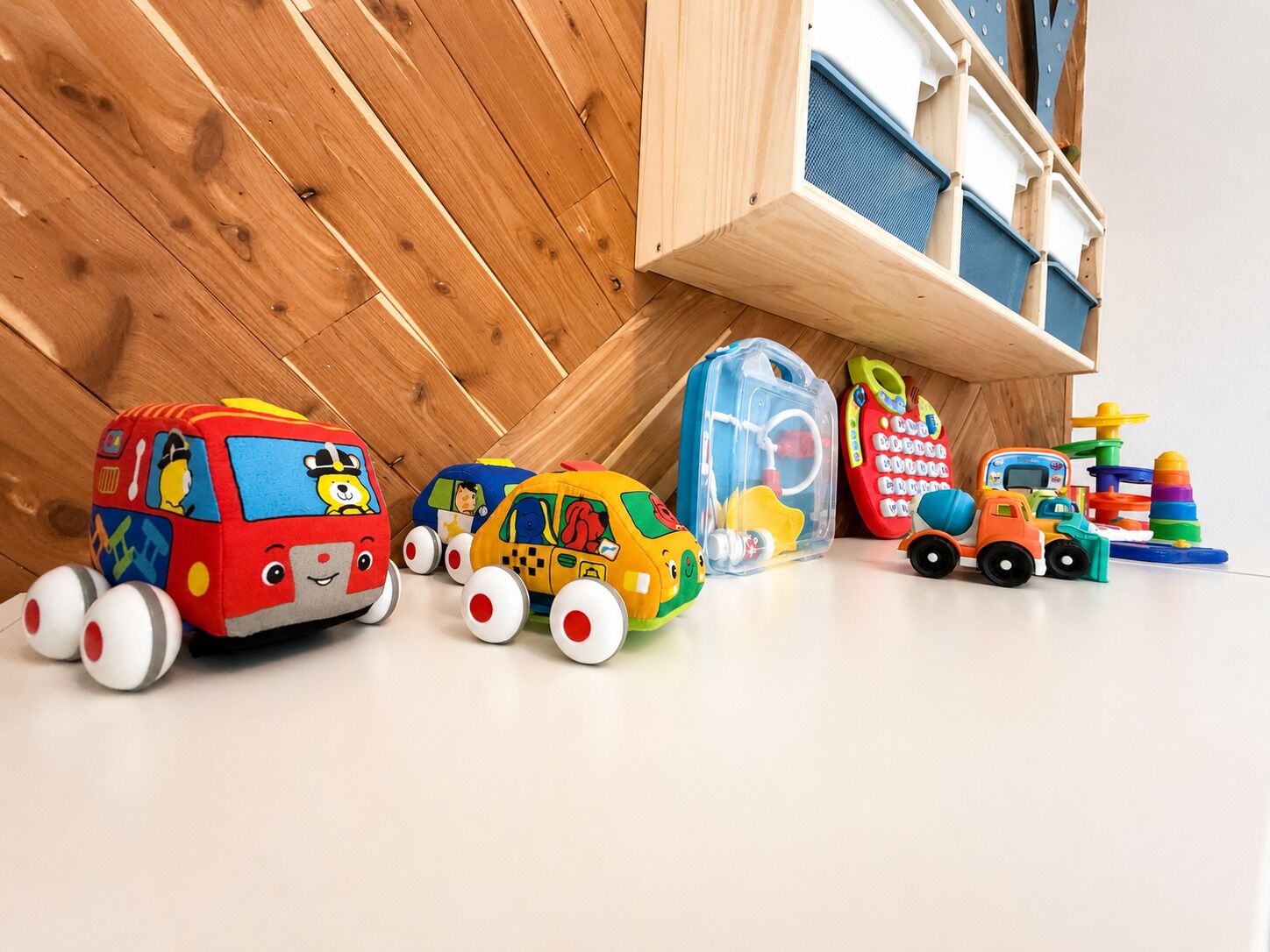 A collection of children's toys including toy vehicles and a storage bin.