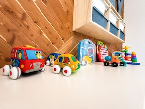 A collection of children's toys including toy vehicles and a storage bin.
