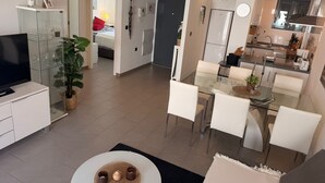 A modern apartment with a living room, dining area, and kitchen. - Penthouse Oasis Beach IV La Zenia (Orihuela)