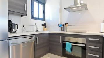 Una cocina moderna con lavavajillas, horno y una ventana sobre el fregadero.