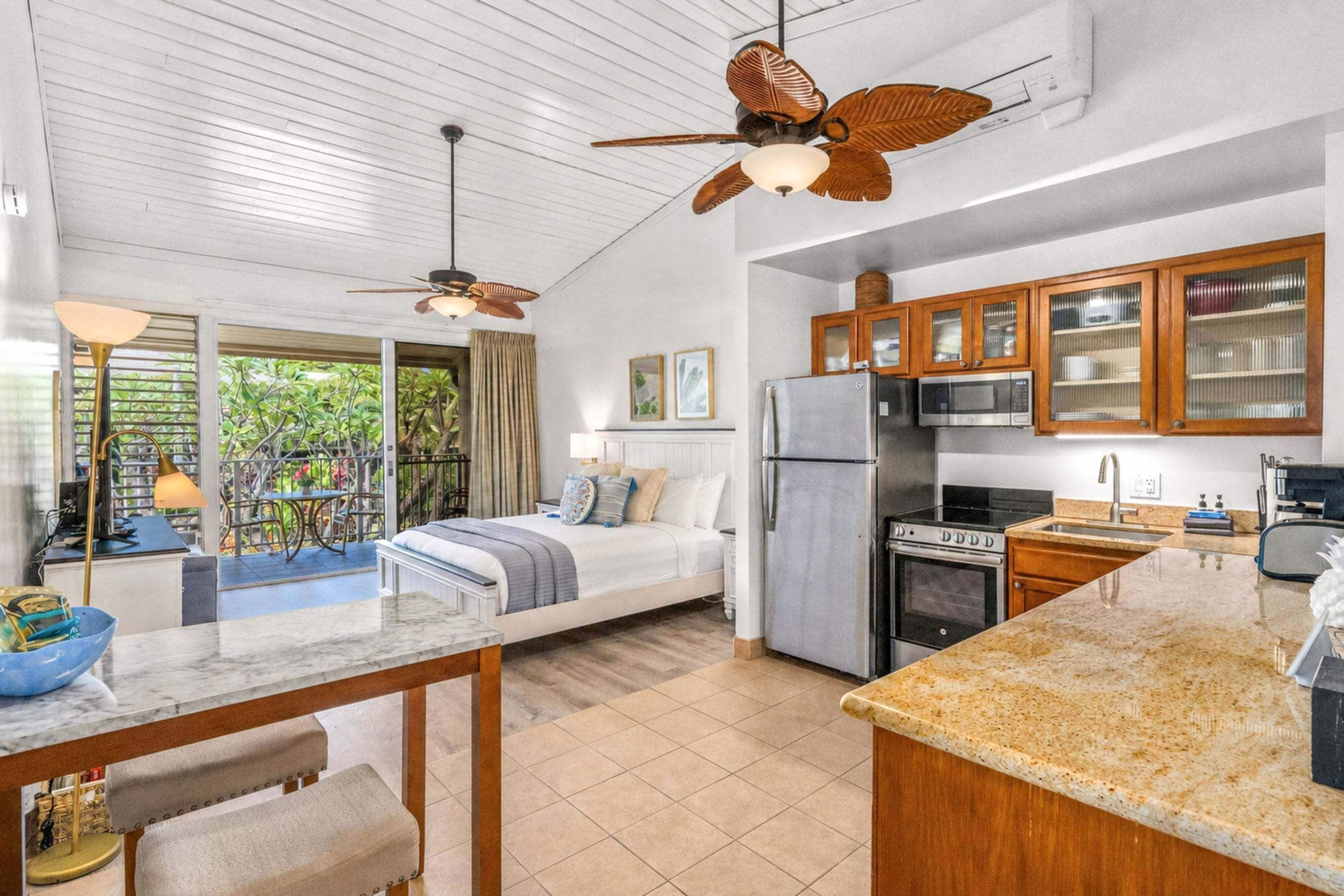 A modern kitchen with a refrigerator, stove, and microwave. There is a dining area with a table and chairs.