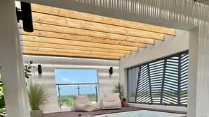 A modern outdoor hot tub area with wooden steps leading up to it, surrounded by potted plants and a view of the sky. - Altamar — Rooftop Penthouse, Private Jacuzzi, Walk to Encuentro Beach, Sleeps 8 (playa encuentro- cabarete)