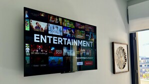 Ein an der Wand montierter Fernseher zeigt verschiedene Unterhaltungsangebote.