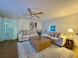 Ein Wohnzimmer mit einer Couch, einem Couchtisch und einem Deckenventilator.