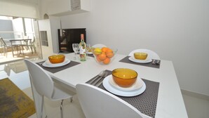Een eettafel gedekt met kommen, een fles en sinaasappels.