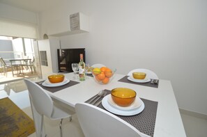 Ein Esstisch mit Schüsseln, einer Flasche und Orangen gedeckt.