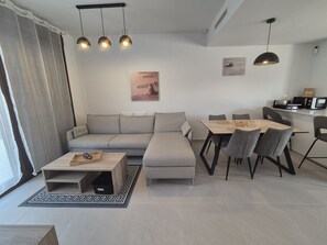A modern living room with a sofa, dining table, and chairs, a coffee table, and pendant lights. - Groundfloor Beliche San Pedro Pinatar (San Pedro del Pinatar)