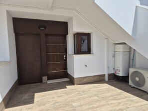 A staircase leading to a door, a small window, and a white air conditioning unit. - Groundfloor Beliche San Pedro Pinatar (San Pedro del Pinatar)