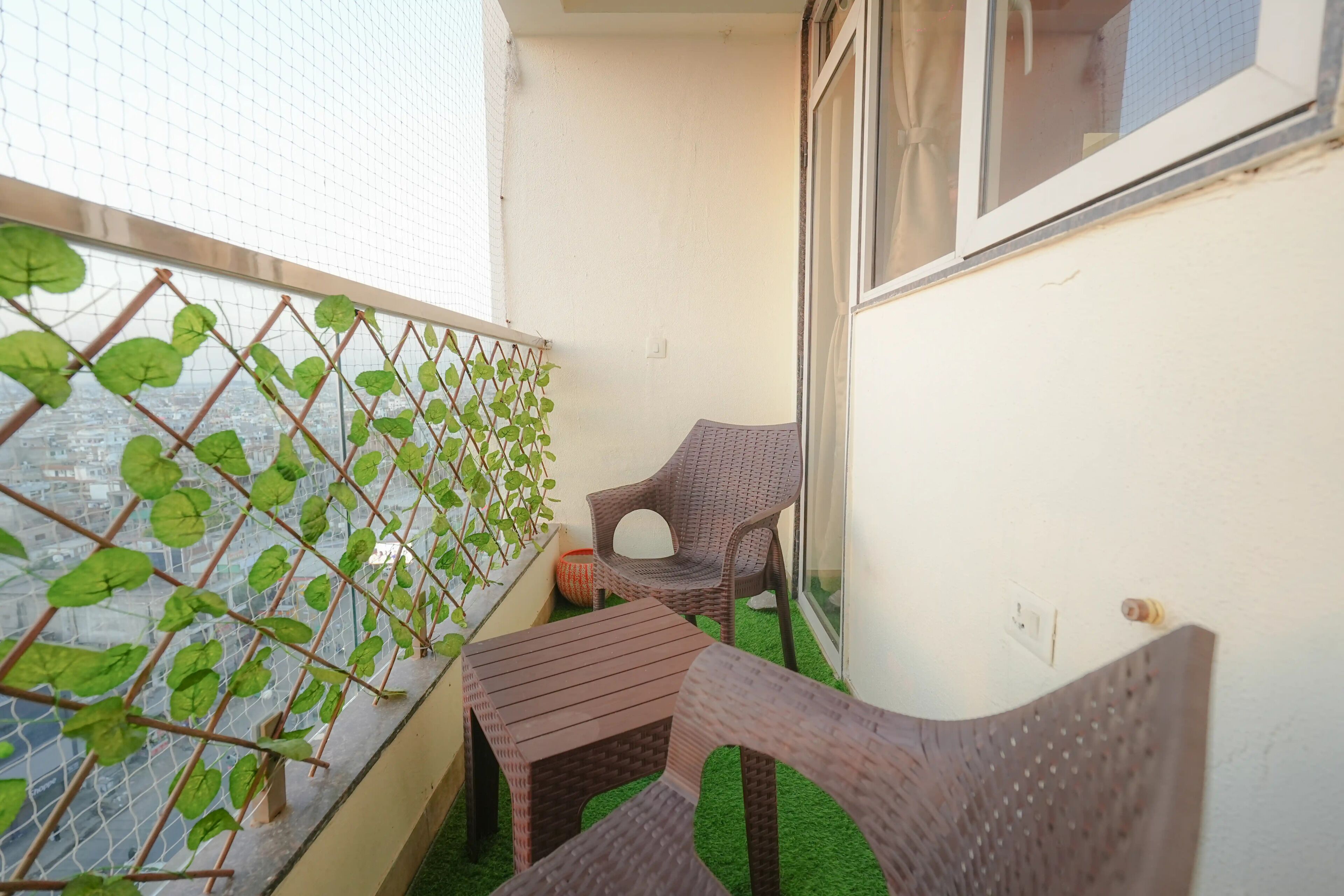 Un balcon avec une chaise, une petite table et un mur végétal.