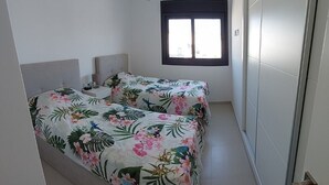 Un dormitorio con cama, ventana y puerta.