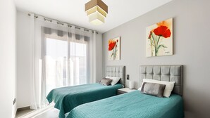 A hotel room with two beds, a large window with sheer curtains, and artwork on the walls. - Penthouse Oasis Beach IX Punta Prima (Torrevieja)