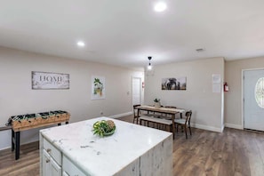 A spacious living area with a foosball table, a dining table, and a kitchen island. - Private 3BR Retreat in Arlington | Sleeps 8 (Arlington)