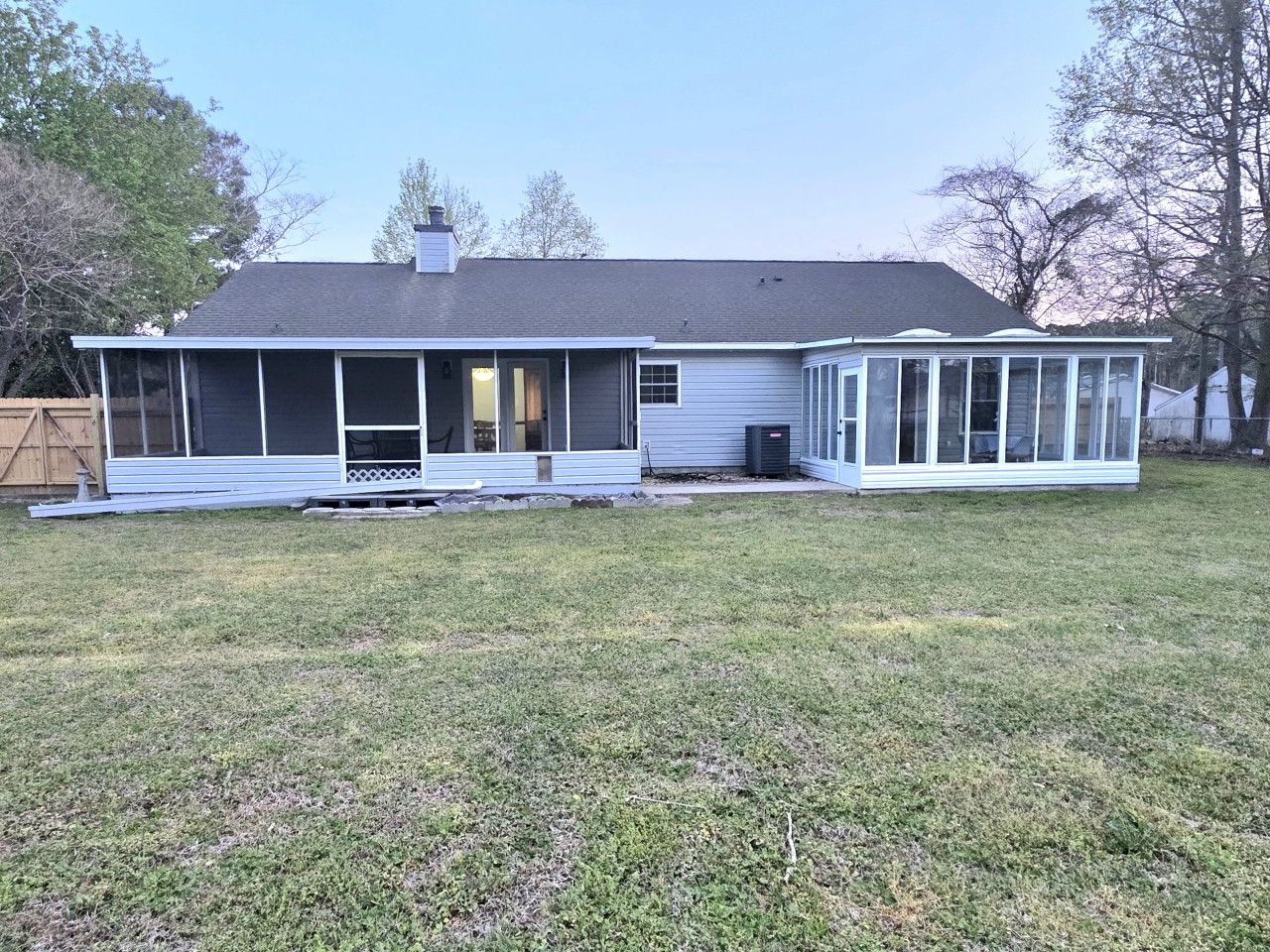 A single-story house with a covered porch and a fenced yard.