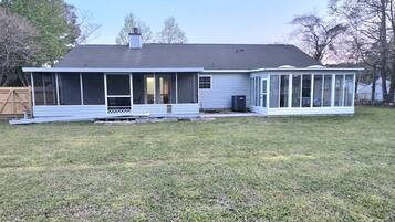 A single-story house with a covered porch and a fenced yard.