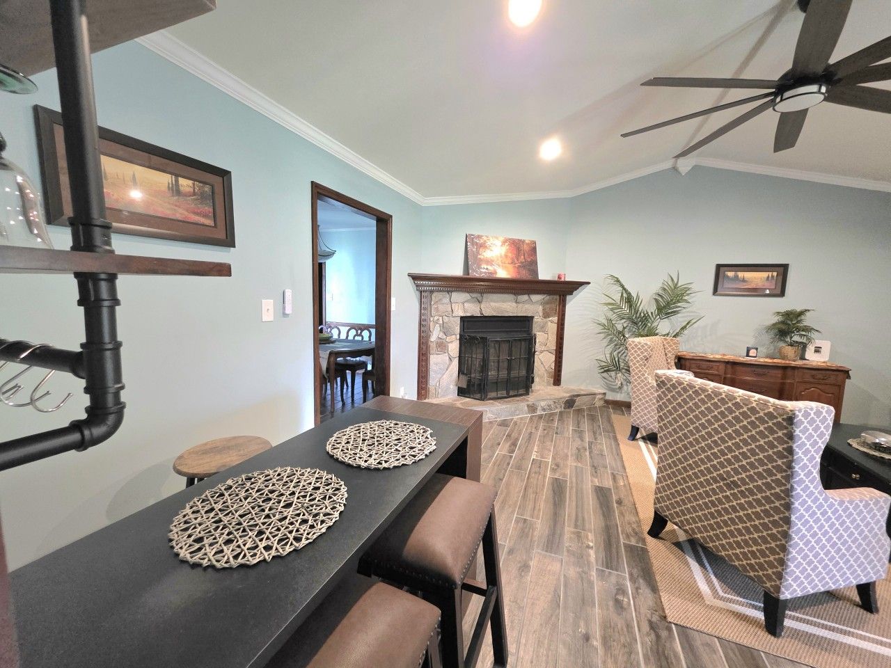 A dining area with a long table, chairs, and a fireplace.