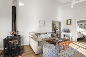 Ein Wohnzimmer mit Sofa, Hocker, Couchtisch und Kamin.