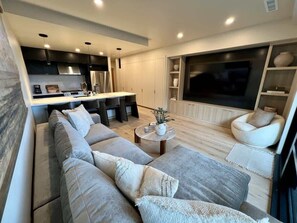 Ein modernes Wohnzimmer mit Sofa, Couchtisch und Fernseher.