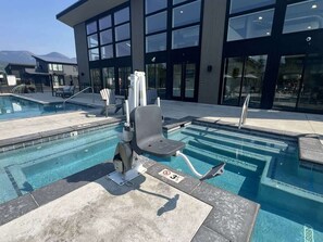 Una piscina amb una cadira de socorrista i una escala.