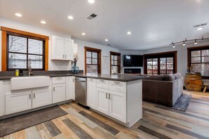 A modern kitchen with white cabinetry, a central island, and a built-in oven. - Downtown Condo, Sleeps 7, 35 Mins to Glacier Park (Whitefish)