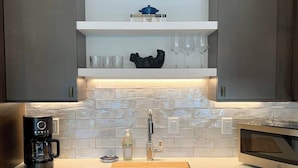 A modern kitchen with a built-in dishwasher, a coffee maker, and a microwave. - Rooftop Patio, Downtown, 40 Mins to Glacier Park (Whitefish)