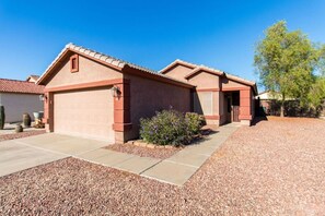 A residential property with a garage, a covered patio, and a landscaped garden.