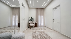 A modern room with a large mirror, a chair, a small table, and a door marked with the number 202. - Villa Golden Sunset Pyramids Inn (Giza)