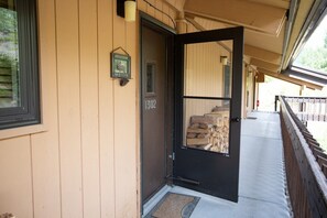 A wooden building with a black door marked '1302' and a welcome sign. - Columbine 1302! Ski-In/Out! Hot Tub! Views! (Crested Butte)