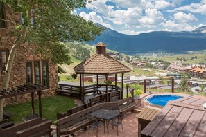 A gazebo with a view of a mountain range, a swimming pool, and outdoor seating. - Columbine 1302! Ski-In/Out! Hot Tub! Views! (Crested Butte)