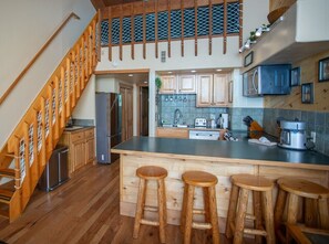 A kitchen with wooden bar stools, a stainless steel refrigerator, and a microwave. - Irene`s Bike/HIke or Ski-In/Out! Hot Tub! Views! (Crested Butte)