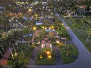 Zona residencial con casas, palmeras y piscina.