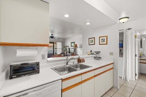 Eine moderne Küche mit Einbauofen, Spülbecken und Holzschränken.