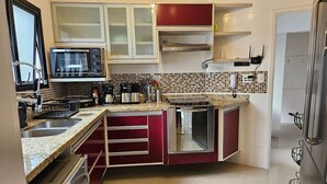Une cuisine équipée d’un four à micro-ondes, d’une cuisinière, d’un évier et de placards.