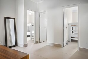 A modern interior with a hallway leading to a bedroom with a bunk bed. - Beachfront with pool - Costa do Sol (Loteamento Costa do Sol)