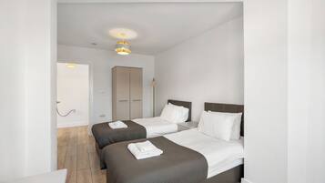 Ett hotellrum med två sängar, en garderob och en taklampa.