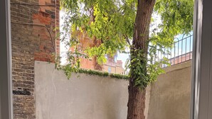A room with a concrete floor, a tree, and a brick wall. - Terrific 2-bedroom apartment in central London perfect for your stay (London)