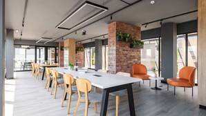 A modern conference room with a long table, chairs, and a brick accent wall. - Steps from Larcomar | 3BR · A/C · Parking (Miraflores)