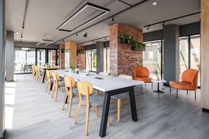 A modern conference room with a long table, chairs, and a brick accent wall. - Steps from Larcomar | 3BR · A/C · Parking (Miraflores)