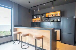 A modern kitchen with a bar area, pendant lighting, and a view through a large window. - Steps from Larcomar | 3BR · A/C · Parking (Miraflores)