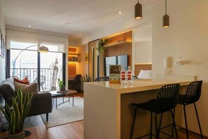 Ein modernes Wohnzimmer mit einer Couch, einem Couchtisch und einem Essbereich mit Stühlen.