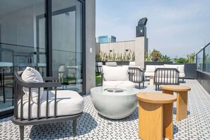A rooftop terrace with outdoor seating, a fire pit, and a view of the city skyline. - Pool · Gym · A/C | San Isidro's Financial District (San Isidro)