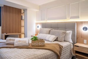 A hotel room with a large bed, a wooden panel wall, and a bedside table with a lamp. - Pool · Gym · A/C | San Isidro's Financial District (San Isidro)