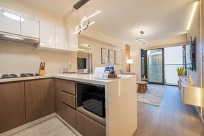 A modern kitchen with built-in appliances, a central island, and a dining area with a view. - Pool · Gym · A/C | San Isidro's Financial District (San Isidro)