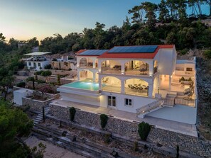 A multi-story villa with a swimming pool, outdoor seating, and a red-tiled roof. - Beachfront Villa Crystal Bay with Pool (Čara)