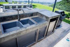 An outdoor kitchen with two sinks, a faucet, and a grill. - Luxury 5-BR villa with private chef, lake views & heated pool (Jal.)